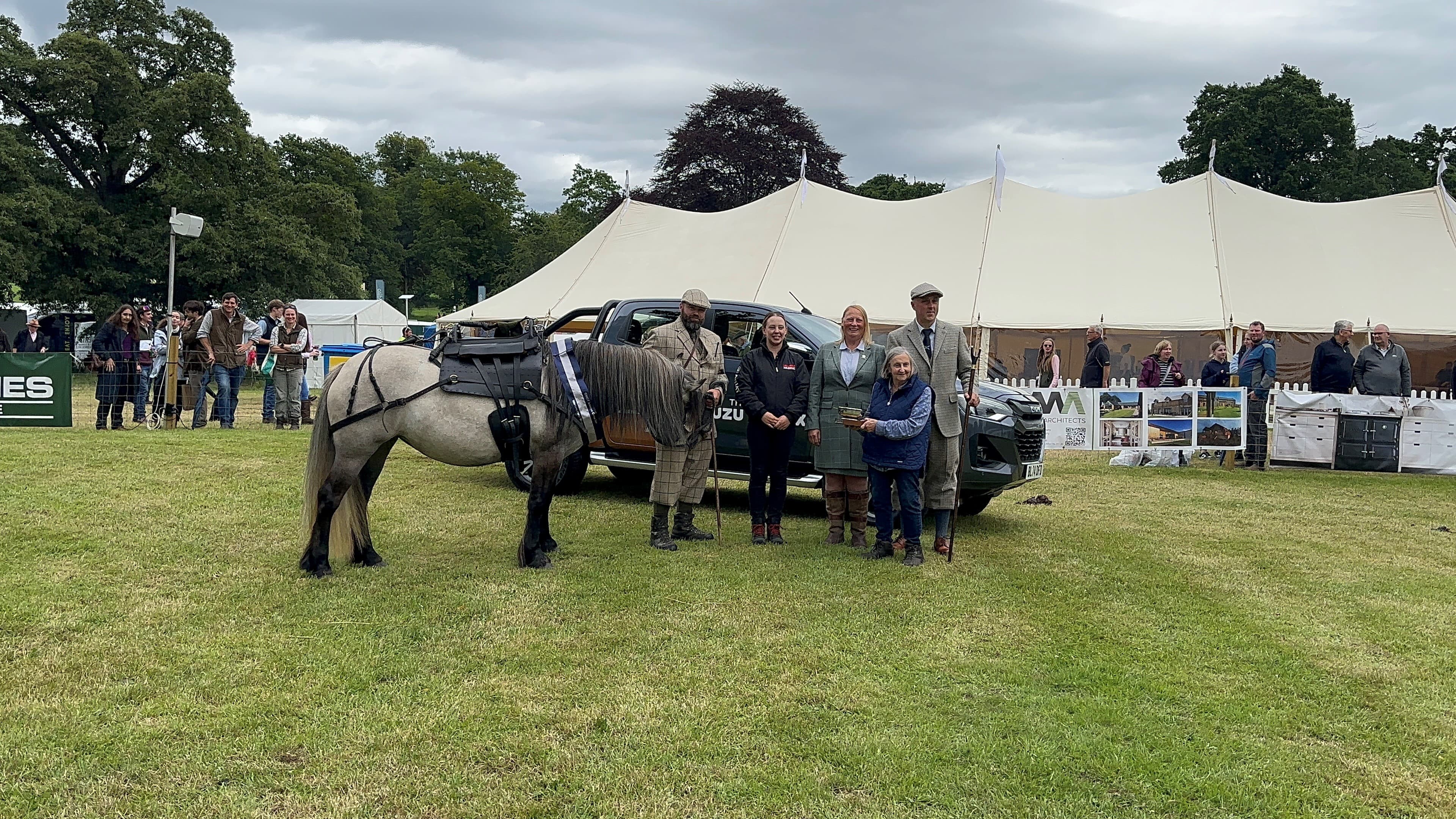 A Highland pony with owners at a showground